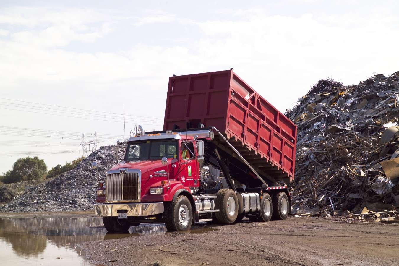 Bin truck roll offs to unload scrap metal